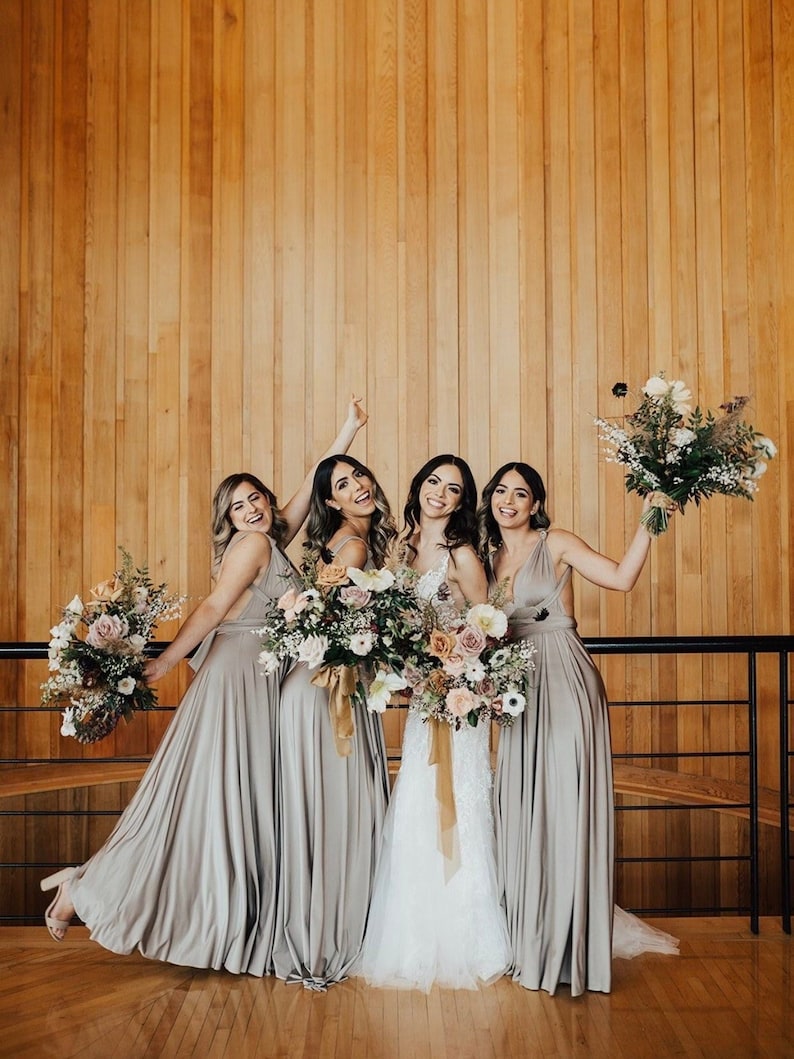 Bride with three bridesmaids in champagne infinity wrap dresses holding bouquets
