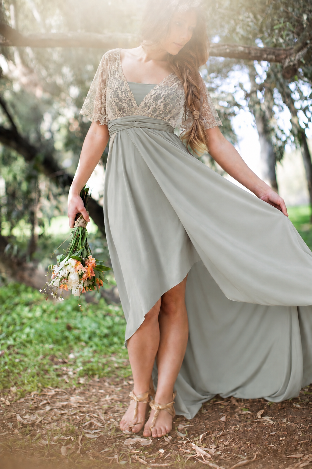 Woodland portrait of a woman wearing a sage tulip cut dress with ivory lace sleeves